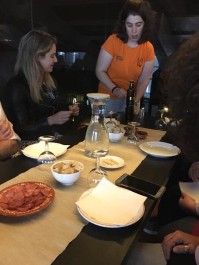 Woman serving group of adults wine in Portugal